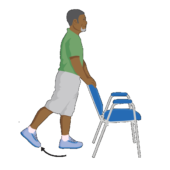 A man stands holding onto the back of a chair while lifting his right leg up and back